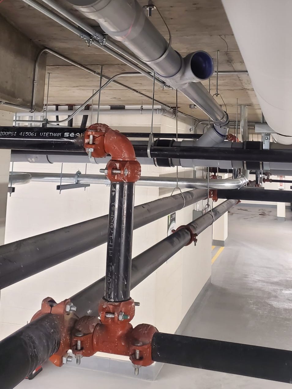 Commercial drain and water piping in a parkade ceiling